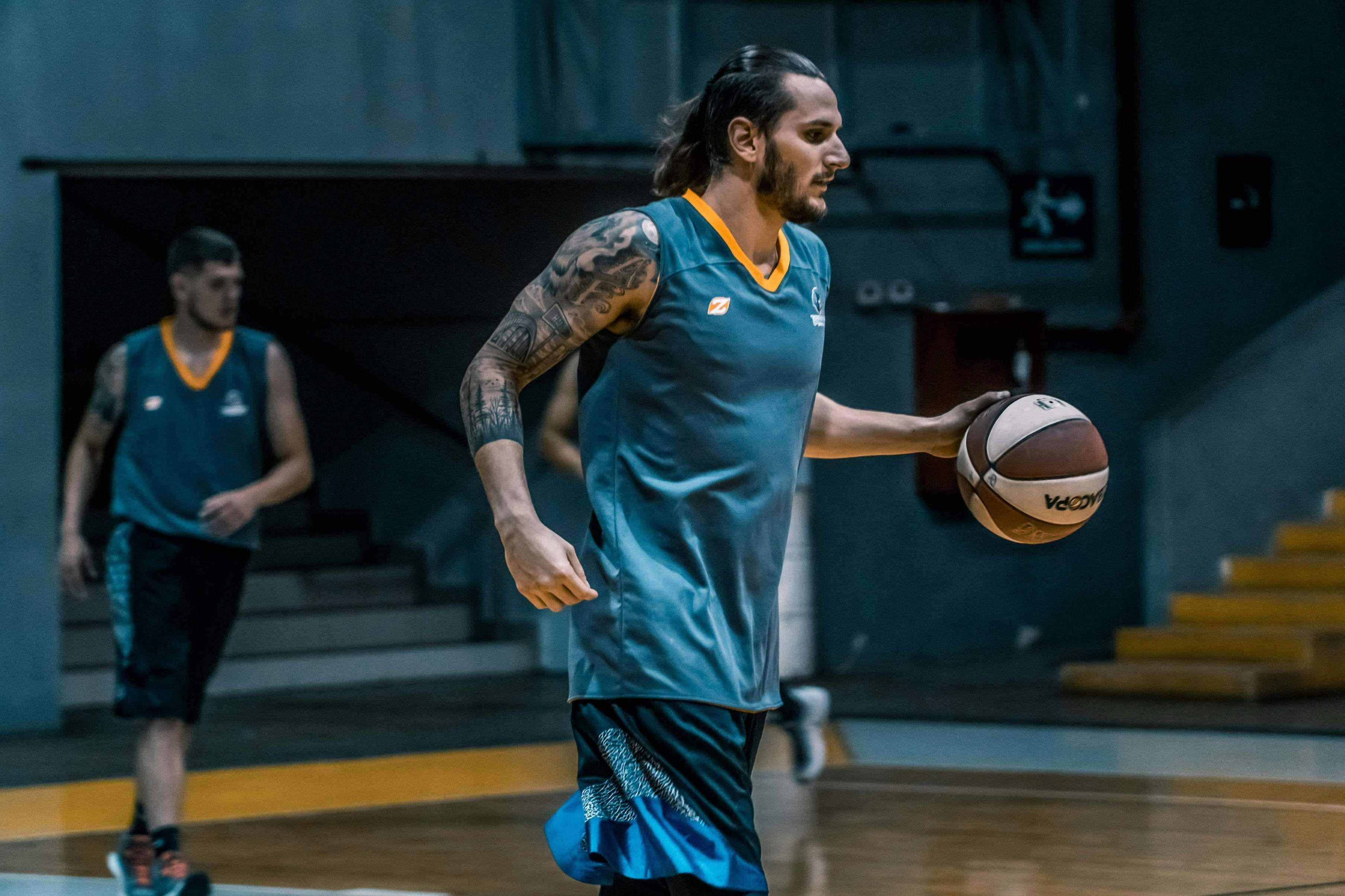 Atleta em um jogo de basquete disputado em ginásio